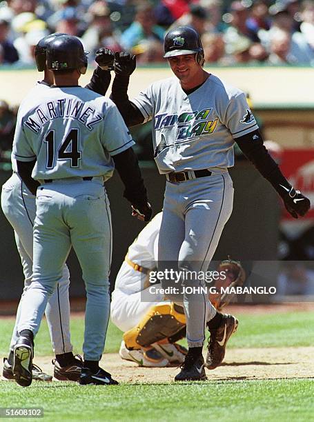 The Tampa Bay Devil Rays' Jose Canseco is greeted by teammates at homeplate after Canseco launched a three-run homerun against the Oakland Athletics...