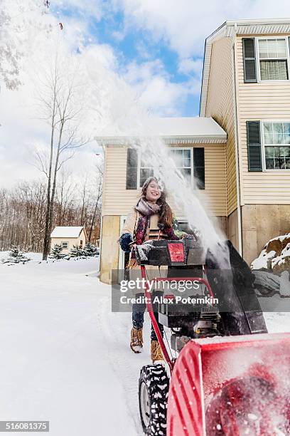 teenager girl remove the snow with snowplow - strooigoed stockfoto's en -beelden