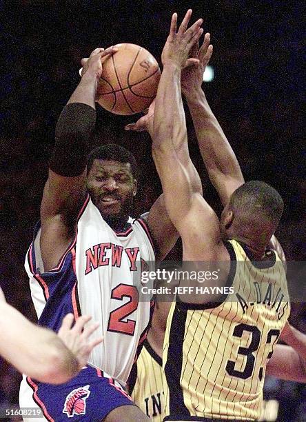 New York Knicks forward Larry Johnson drives to the basket against Antonio Davis of the Indiana Pacers 05 June during game three of the NBA Eastern...