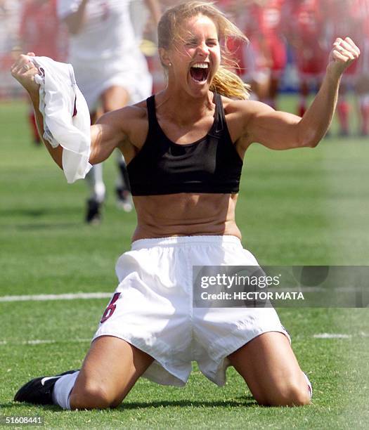 Brandi Chastain of the US shouts after falling on her knees after she scored the last goal in a shoot-out in the finals of the Women's World Cup with...