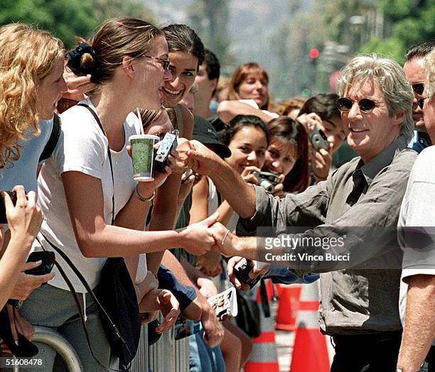 Actor Richard Gere shakes hands with fans after he placing his hands and feet in cement during ceremony at Mann's Chinese Theatre 26 July 1999 in...