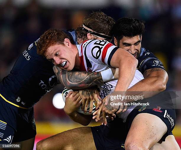 Dylan Napa of the Roosters is tackled by James Tamou and Ethan Lowe of the Cowboys during the round three NRL match between the North Queensland...