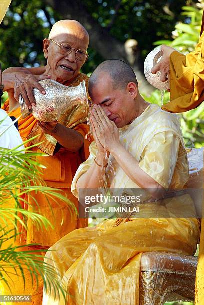 Cambodian Supreme monks pour holy water on their new King Norodom Sihamoni during a religious ceremony at the Royal Palace in Phnom Penh 29 October...