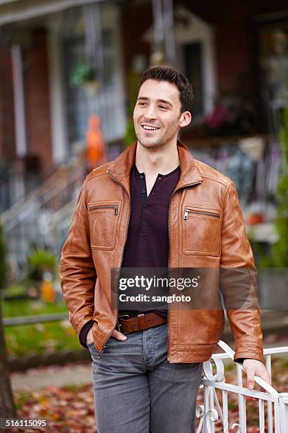 retrato de um homem de casaco de couro marrom sorridente permanente cidade de outono - cinto de pele imagens e fotografias de stock