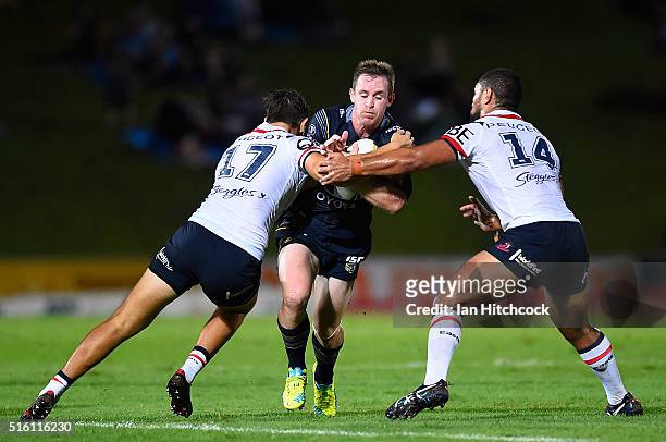 Michael Morgan of the Cowboys is tackled by Mitchell Frei and Isaac Liu of the Roosters during the round three NRL match between the North Queensland...