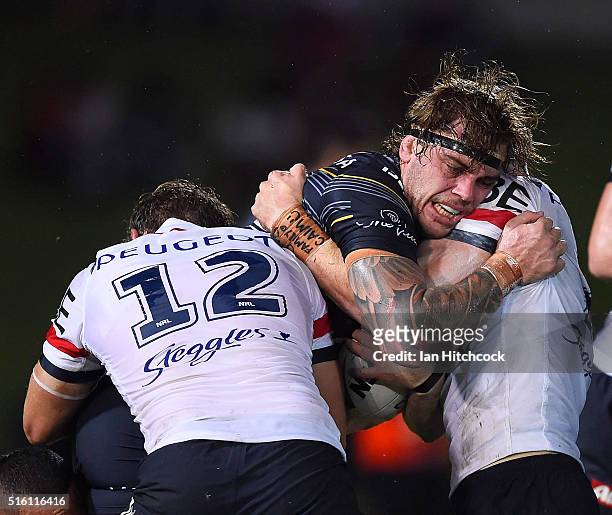 Ethan Lowe of the Cowboys is tackled by Mitchell Aubusson of the Roosters during the round three NRL match between the North Queensland Cowboys and...