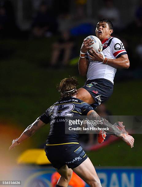 Latrell Mitchell of the Roosters takes a high ball in front of Ethan Lowe of the Cowboys during the round three NRL match between the North...