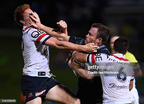 Gavin Cooper of the Cowboys fends Dylan Napa of the Roosters during the round three NRL match between the North Queensland Cowboys and the Sydney...