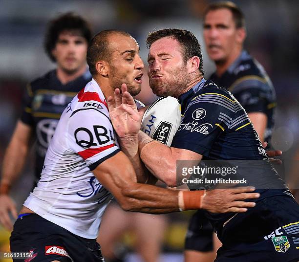 Gavin Cooper of the Cowboys is tackled by Blake Ferguson of the Roosters during the round three NRL match between the North Queensland Cowboys and...