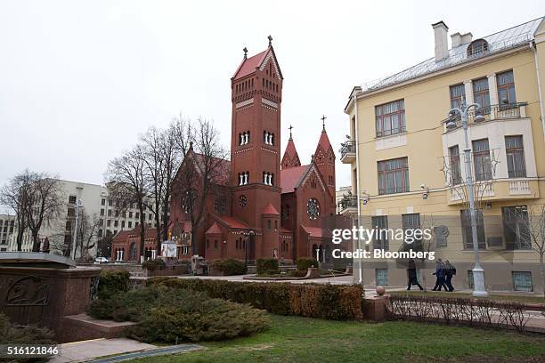 Pedestrians walk across Independence square and past the Church of Saints Simon and Helen in Minsk, Belarus, on Wednesday, March 16, 2016. European...