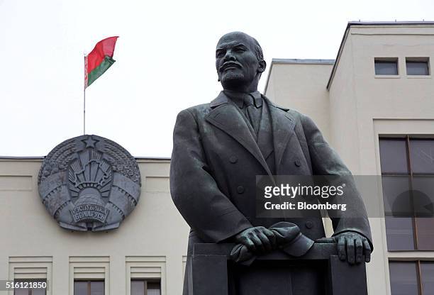 The national flag of Belarus flies on a state building above a statue of former Communist Party founder Vladimir Lenin on Independence square in...