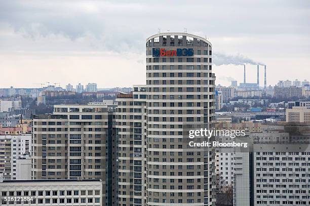 Chimneys emit vapour across the city skyline beyond an advertising logo for the OJSC Bank BellVEB, also known as Belvnesheconombank, on a high rise...