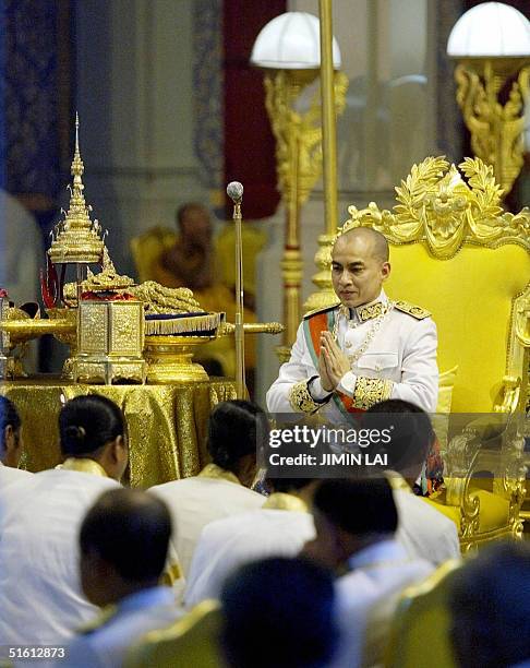 Facing his subjects, Cambodia's King Norodom Sihamoni sits on his throne beside his crown and sword during his coronation ceremony at the Royal...