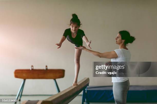 girl practicing gymnastics - kids gymnastics stock pictures, royalty-free photos & images