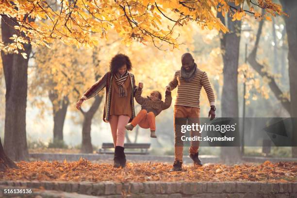 african american family walking and having fun in autumn park. - young leafs stock pictures, royalty-free photos & images