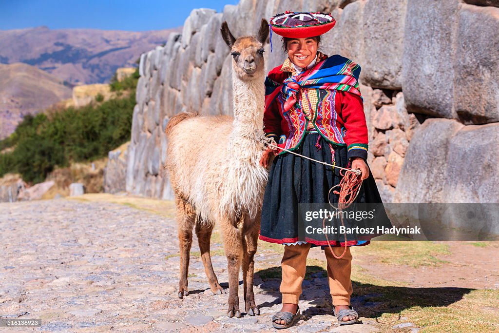 Peruvian girl posing with llama near Cuzco