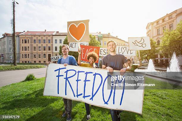 three young activists demonstrating with banners - march 22 2013 stock pictures, royalty-free photos & images