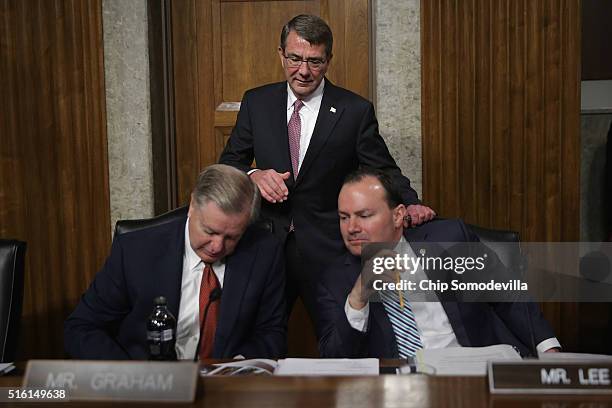 Secretary of Defense Ashton Carter tries to get the attention of Senate Armed Services Committee members Sen. Lindsey Graham and Sen. Mike Lee before...