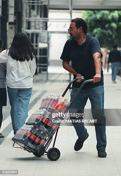 Man transports bottles of Coca Cola in a central street in Mexico City 22 June 1999. Mexico is the second-largest consumer of cola drinks outside of...