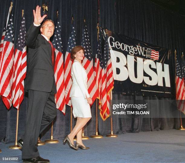 Texas Governor George W. Bush and his wife Laura arrive onstage at The Washington Hilton hotel for what the Bush Presidential Exploratory Committee...