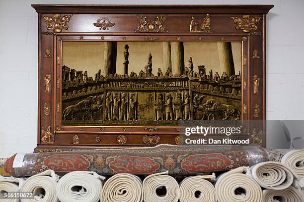 An image of ancient Persepolis hangs above Persian Rugs at the Oriental Rug Centre's main warehouse on March 17, 2016 in London, England. The...