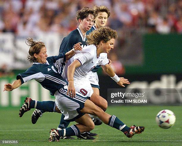 Michelle Akers of the US tries to get past German players Sandra Smisek 01 July, 1999 during the quarter-final match of the Women's World Cup between...