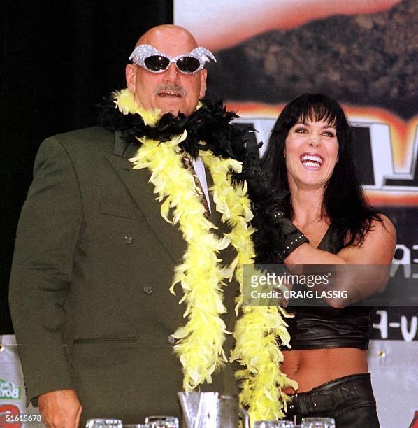 Minnesota Governor and former professional wrestler Jesse Ventura is adorned with his former trademarks, sequined sunglasses and a feather boa, by...