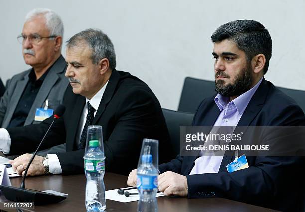 Members of the delegation of the High Negotiations Committee Mohamed Alloush Asaad Al-Zoubi and George Sabra wait prior to a meeting with U.N....
