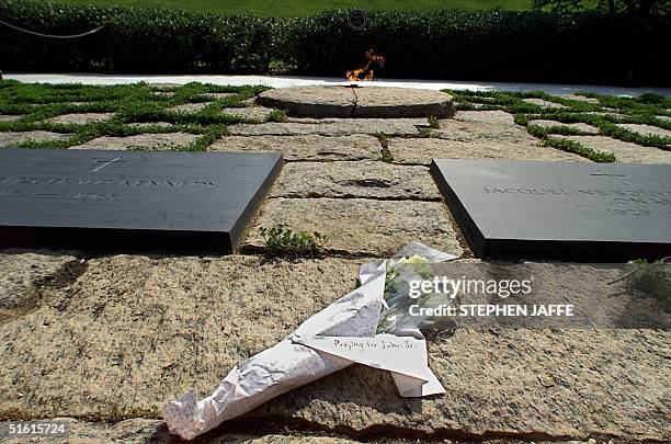 Bouquet of flowers with a message lie between the grave sites of US President John F. Kennedy and his wife Jacqueline Onassis Kennedy at Arlington...