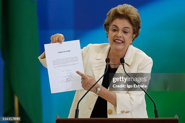 Brazil President Dilma Rousseff holds a paper as she speaks as former president Luiz Inacio Lula da Silva is sworn in as the new chief of staff on...