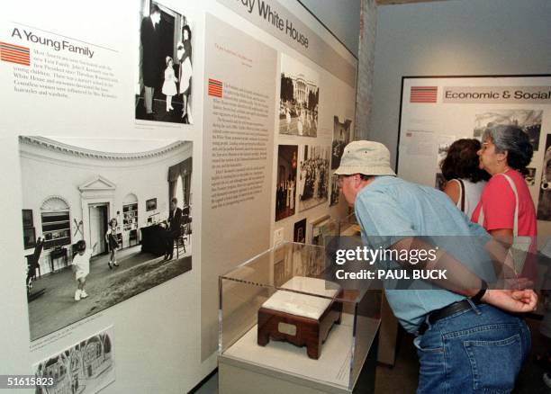 Tourists pause to look at photos of the Kennedy family made during John F. Kennedy's term as US president displayed in the Sixth Floor Museum 20 July...