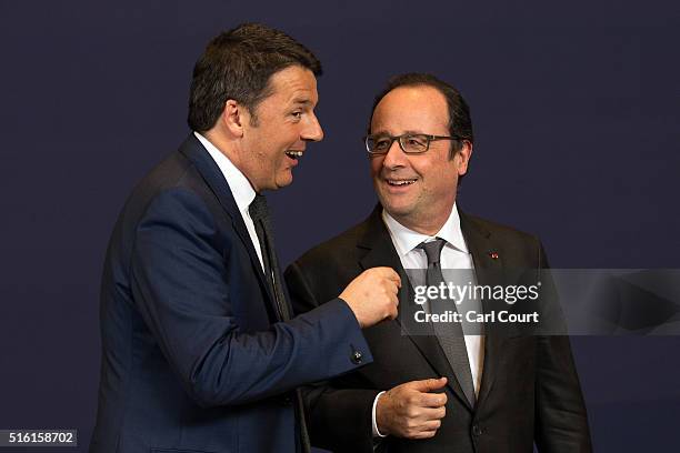 Italy's Prime Minister Matteo Renzi talks with France's Prime Minister Francois Hollande after a group photograph on the first day of an EU summit at...