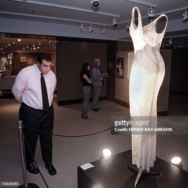 Man views the "Happy Birthday Mr. President" dress 26 July 1999 at Christies in New York. The dress, worn by Marilyn Monroe during her famous tribute...