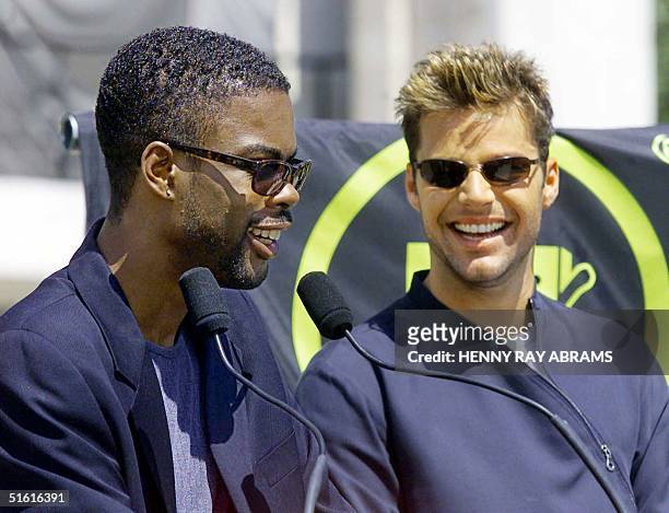 Pop star Ricky Martin listens as comedian Chris Rock announces the nominations for the MTV Music Video Awards at the Lincoln Center in New York 28...