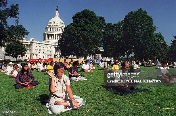 Members of the Falun Gong meditation group meditate 29 July 1999 outside the US Capitol in Washington, DC. The group said that they have received...