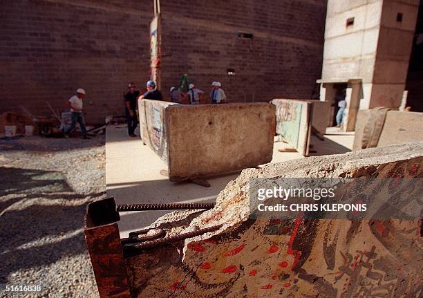 Workers install pieces of the Berlin Wall 04 August 1999 as part of an exhibit at the Newseum news museum in Arlington, Virginia. The exhibit, which...