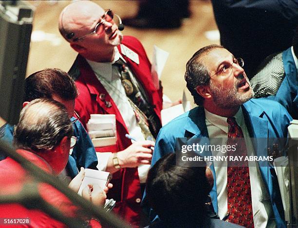 Traders on the floor of the New York Stock Exchange monitor the early moves of the market soon after the trading day began in New York 05 August,...