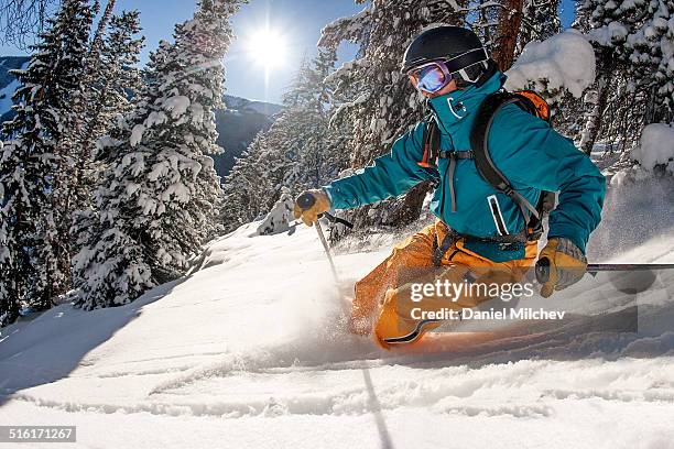skier skiing powder on a sunny day. - ski fotografías e imágenes de stock