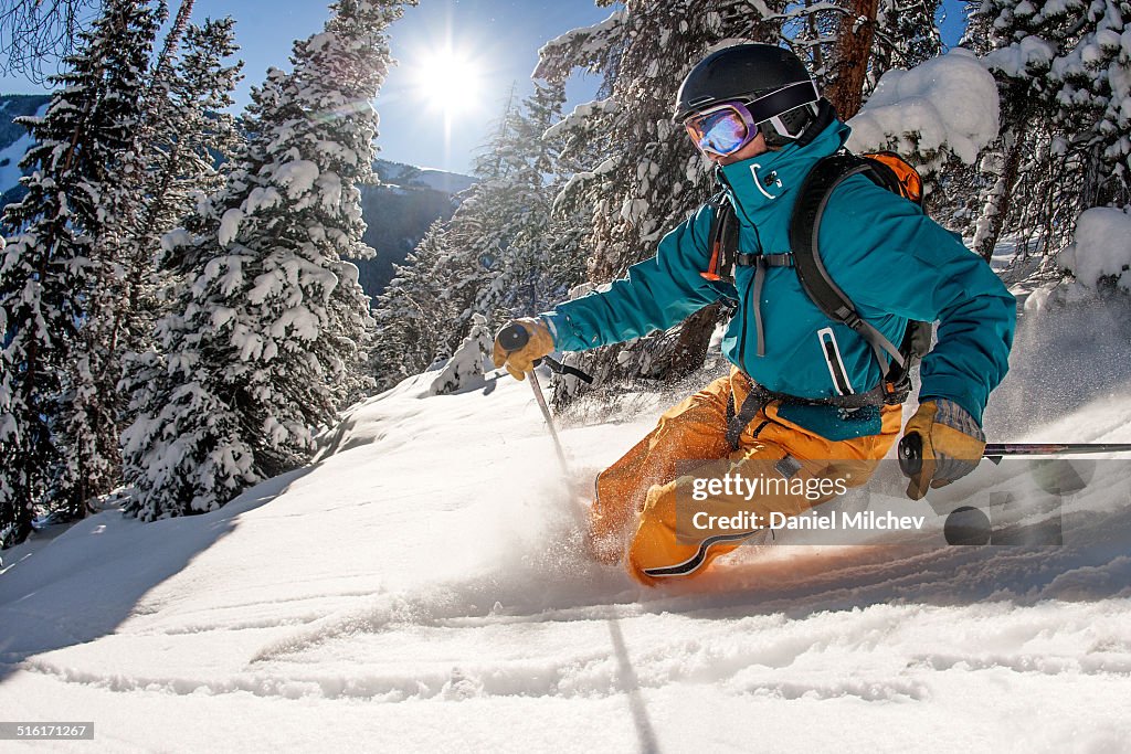 Skier skiing powder on a sunny day.