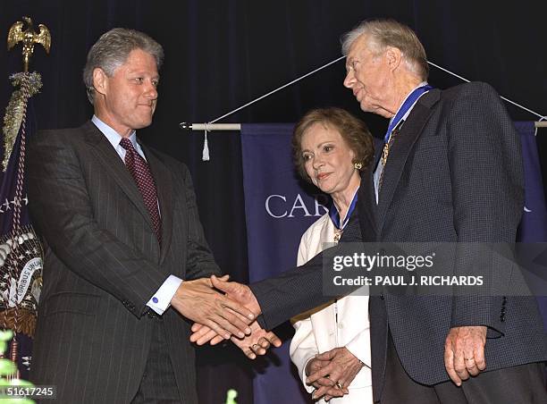 President Bill Clinton shakes hands after presenting former US President Jimmy Carter and his wife Rosalynn with the US Medal of Freedom 09 August...