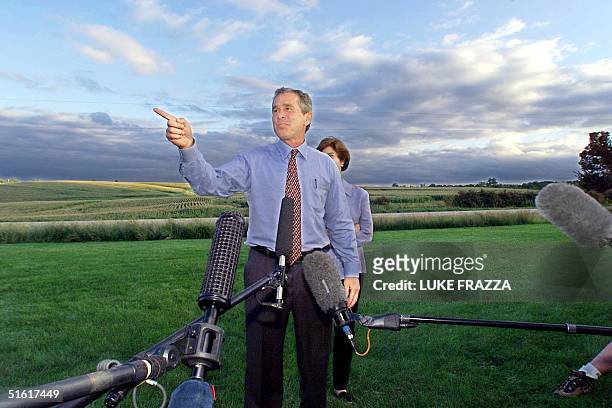 Texas Governor George Bush , a Republican candidate for President, speaks to reporters at a "Front Porch Picnic" 13 August in Indianola, IA, next to...