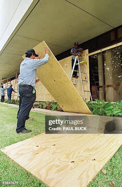 City of Victoria, Texas, employees place plywood over plate glass windows at the Victoria Public Library in anticipation of the arrival of Hurricane...