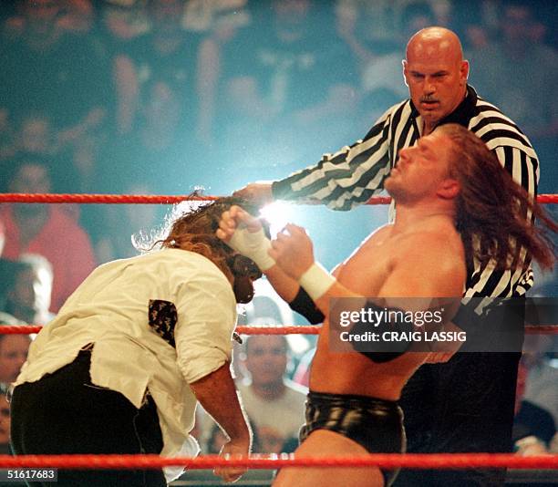 Minnesota Governor and former professional wrestler Jesse Ventura watches over the action as a guest referee during the World Wrestling Federation...
