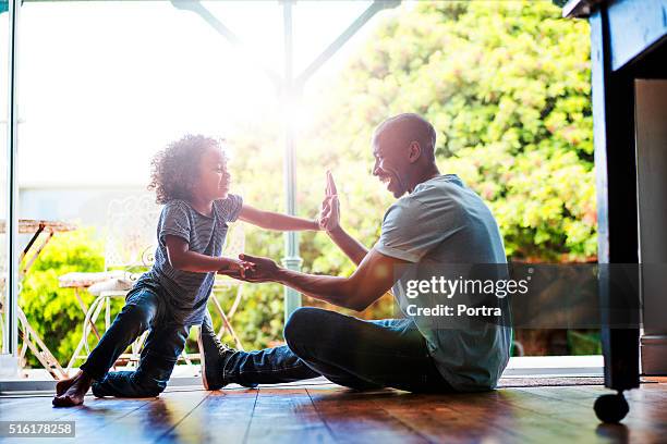 glückliche vater und sohn spielen auf etage wie zu hause fühlen. - bodenleger stock-fotos und bilder