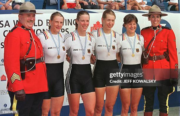 German quadruple scull rowers Maren Derlien, Meike Evers, Manuela Lutze and Kerstin Kowalski pose with a couple of Royal Canadian Mounted Police...