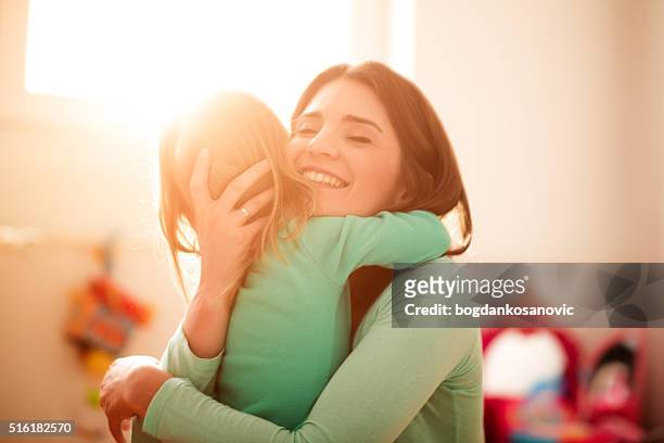 mother and daughter hugging - family hugging bright stockfoto's en -beelden