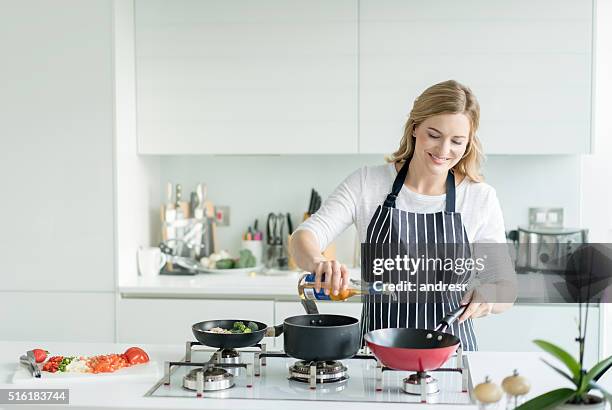 happy woman cooking at home - cooking apron stock pictures, royalty-free photos & images