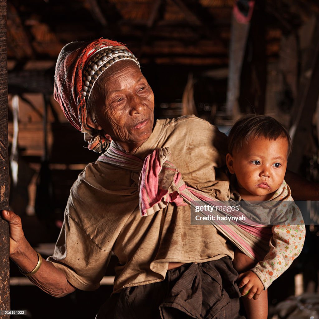 Old Lao woman holding a baby in Northern Laos