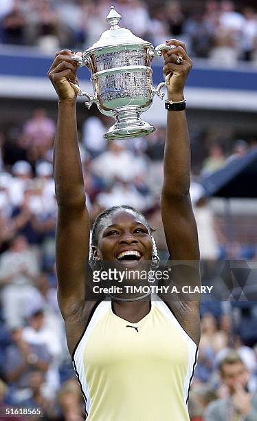 Serena Williams of the US holds the US Open trophy after defeating number one seed Martina Hingis of Switzerland 11 September at the US Open Womens...