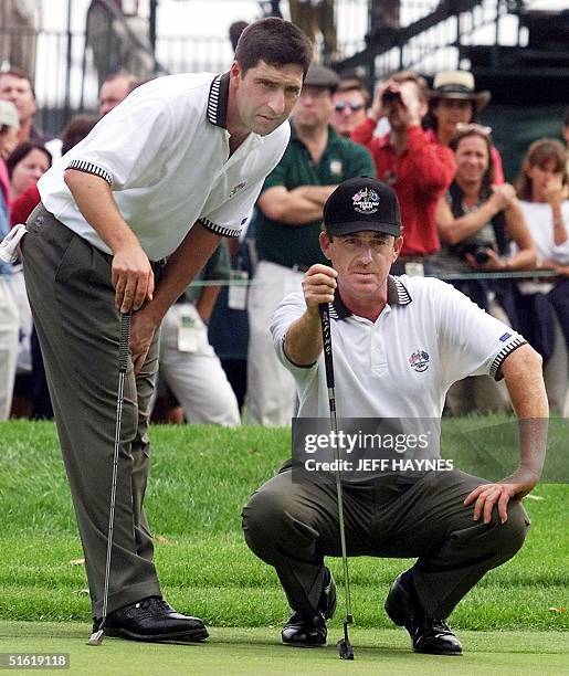 European Ryder Cup team members Jose Maria Olazabal and Miguel Angel Jimenez, both of Spain, study a putt on the eighth green 21 September 1999...